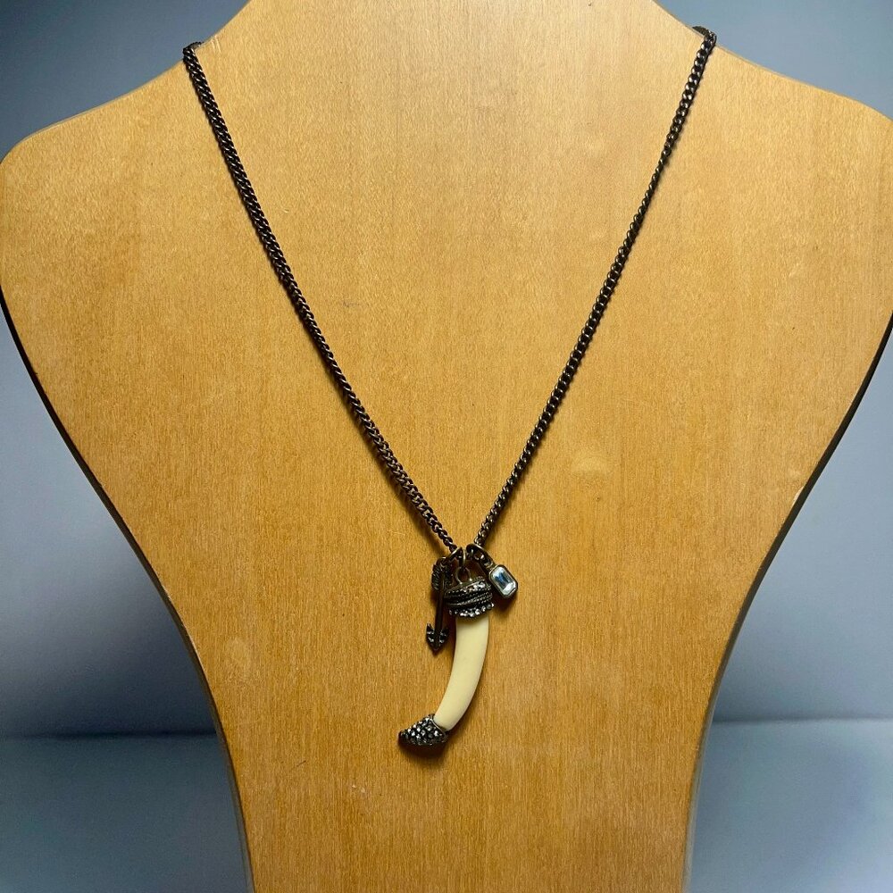 Dark Chain Featuring Tusk-Shaped Object with Arrow Charm and a Clear Gem.